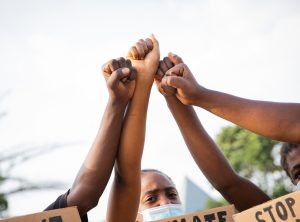 Close-up of the raised fists of a group of African guys protesting